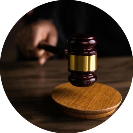 Person striking a brown gavel on a table
